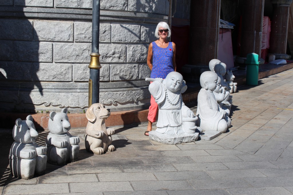 Janis and some statues of cartoon characters and Buddhas.