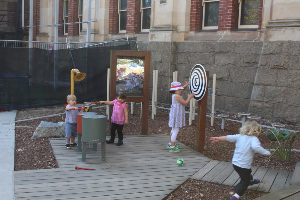Children playing at the percussion playground outsie the Western Australia Museum.
