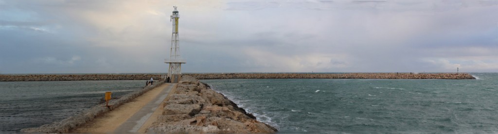 The breakwaters. There is open water between the end of the light beacon and the distant breakwater. 